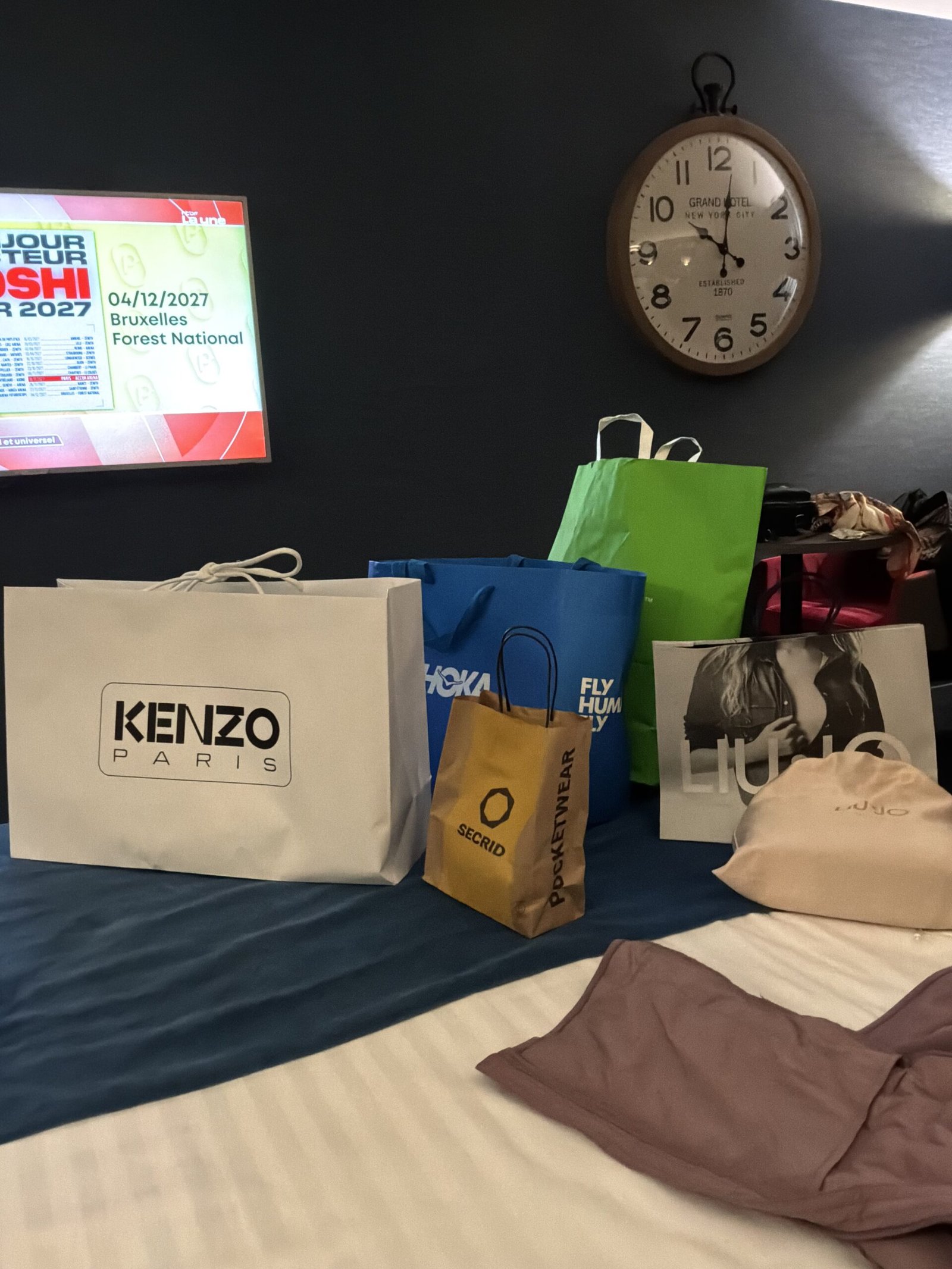 Sacs de shopping de l'outlet de Roermond sur un lit d'hôtel