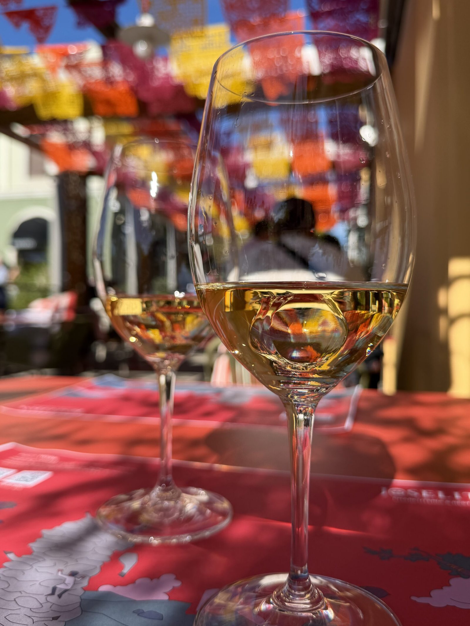 Bouteille de cava Juvé & Camps dans un seau à glace sous les guirlandes colorées de Las Rozas Village